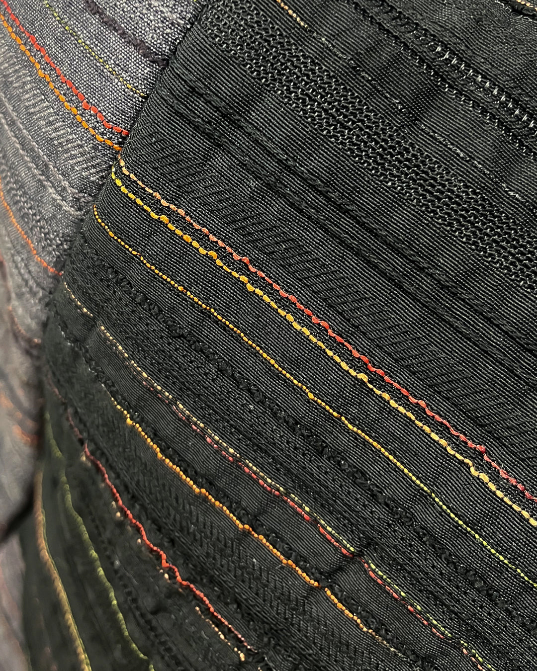 detalle del tejido del Bolso origami de Luci Collection en negro y gris con textura de colores