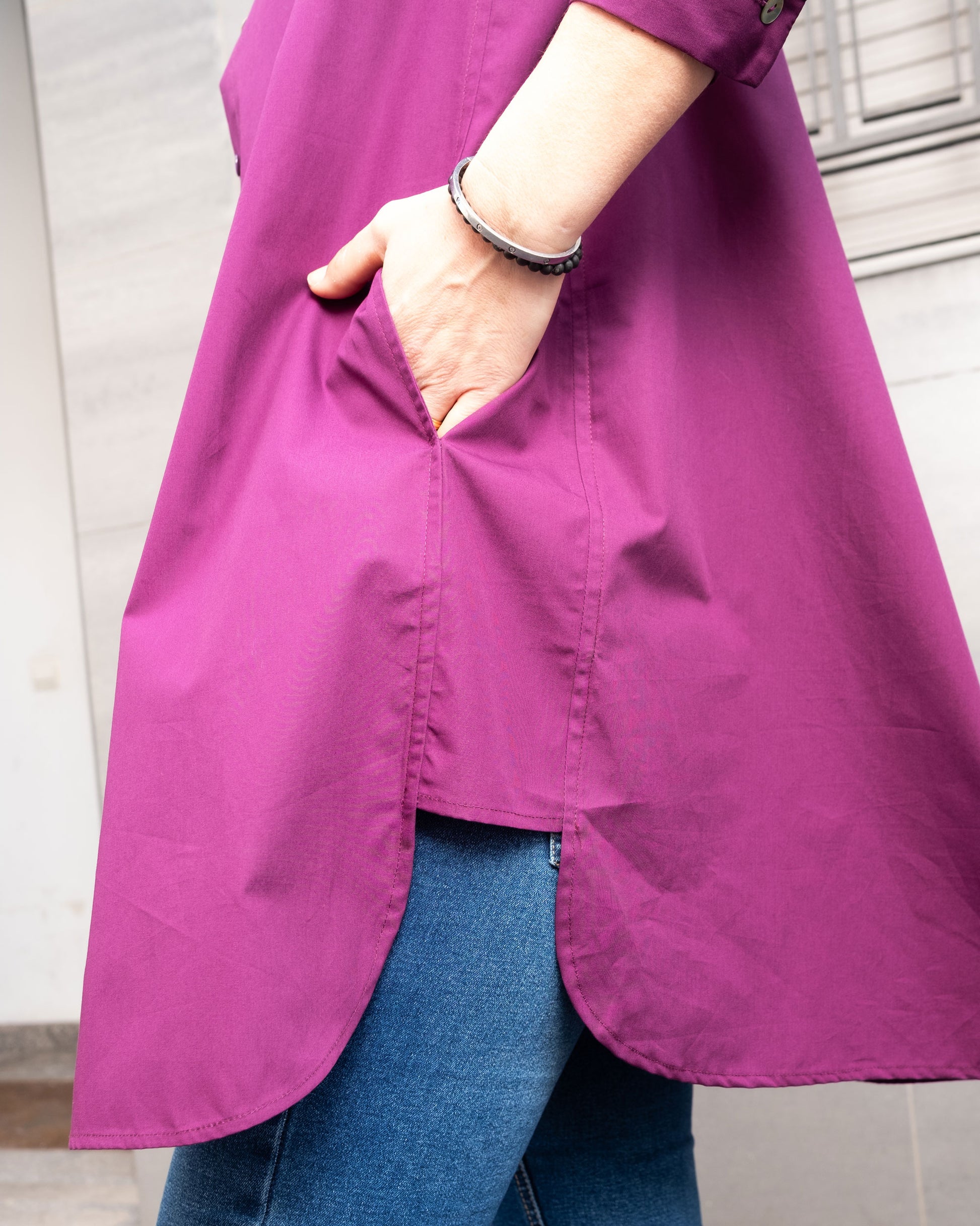 Detalle de los bolsillos laterales de la camisola larga en color berenjena en popelín de algodón